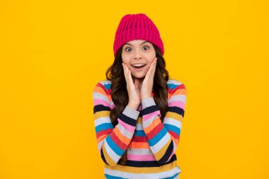 Winter hat. Cold season concept. Winter fashion accessory for children. Teen girl wearing warm knitted hat. Happy teenager, positive and smiling emotions of teen girl