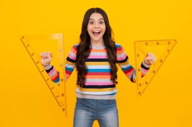 Amazed teenager. Teenager school girl study math or geometry lesson, measure the size. Mathematics ruler for measuring. Excited teen schoolgirl