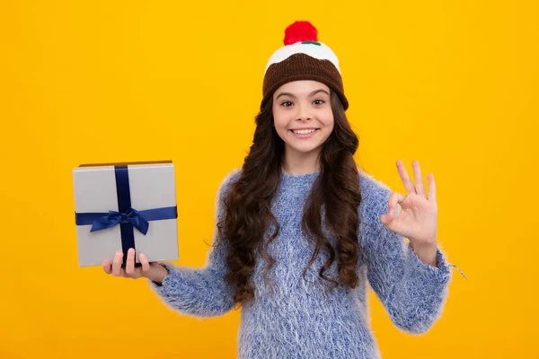 Child with gift present box on isolated background. Presents for birthday, Valentines day, New Year or Christmas. Happy teenager, positive and smiling emotions of teen girl