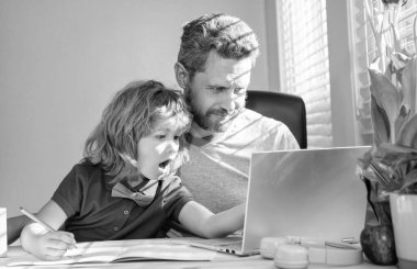 Olgun erkek öğretmen ya da baba çocuğa okul ödevlerinde yardım ediyor. Bilgisayar, aile....