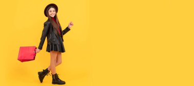 Şapkalı ve deri elbiseli mutlu genç kız alışveriş torbası, alışveriş torbası. Alışveriş yapan kız çocuğu afişi, fotokopi alanı olan poster başlığı