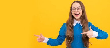 Sarı arka plan fotokopi alanının reklamını yaptığı için okuldaki çocuk parmakla işaret ediyor. Çocuk yüzü, yatay poster, izole edilmiş genç kız portresi, fotokopi alanı olan pankart