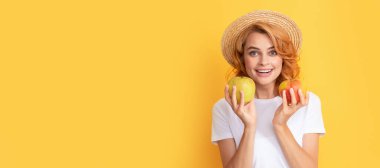 Yaz kızı elmayı tutuyor. Hasır şapkalı neşeli kızıl kız elmalı, vitaminli. Güzel kadın, izole edilmiş yüz portresi, taklit alanı olan pankart.