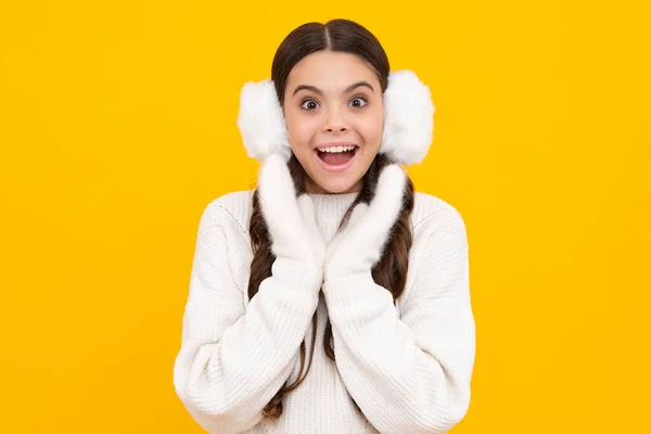 冬の暖かい耳を持つ10代の女の子は 孤立した黄色の背景の上に耳フラップ 冬のクリスマス休暇 新年の気分 子供の暖かい服 興奮したティーン女の子 — ストック写真