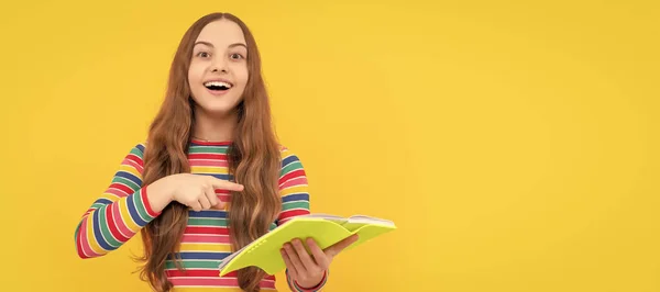 Щаслива Дитина Посміхається Вказуючи Пальцем Шкільну Книгу Жовтого Фону Вчиться — стокове фото