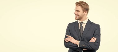 Kendine güvenen bir çalışan iş elbisesiyle mutlu bir gülümseme kollarını kavuşturur, kendine güvenir. İnsan yüzü portresi, fotokopi alanı olan pankart. Takım elbiseli bir iş adamı, izole stüdyo geçmişi var.