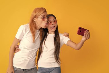 Görüntülü arama yapıyorum. Anne-kız vloglama. Online iletişim. Anne ve çocuk blogcuları. Mutlu kadın ve kız telefonla selfie çekiyorlar. Selfie ailesi. Modern hayat. mobil teknoloji.