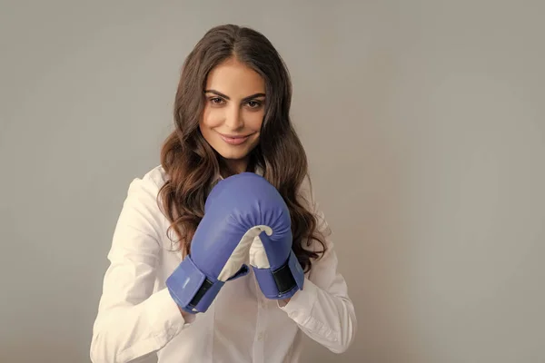 Woman in boxing gloves. Business woman with boxing gloves isolated on gary background