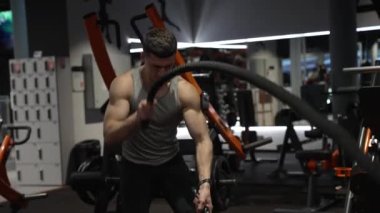 Spor salonunda halatla antrenman yapan güçlü bir sporcu. Spor salonunda halatı olan bir sporcu. Spor salonundaki spor ip ekipmanlarıyla bir sporcu..