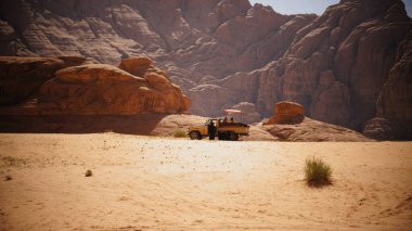 Kızıl kayada bir çift, antik çöl manzarası.