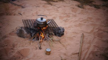 Su ısıtıcısı ve şenlik ateşiyle eski ve kirli kahve demliği.