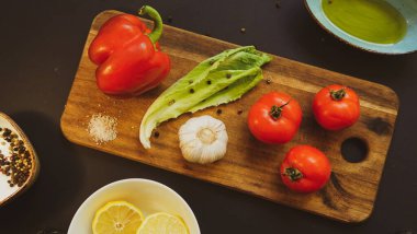 Tahtadaki taze sebzeler ve otlar taze sebzeler ve tahta salata malzemelerinin üzerinde bitkiler.