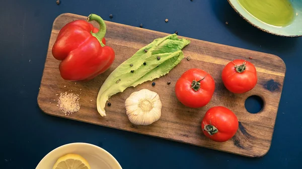 Taze sebzeler, domates ve sarımsak cam şişede taze sebzeler ve tahta salata malzemelerinin üzerinde bitkiler.