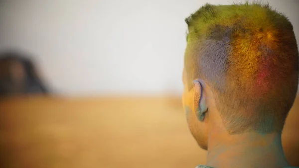a man with multi-colored dyed hair on the background of a desert landscape. rear view of the back of the head close up