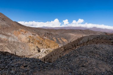 Dağın tepesinden manzara. Dağlardan oluşan farklı renkte bir manzara ve kıvrımlı bir rota görebilirsiniz..