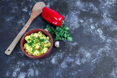 Hazırlanmış pirinç ve baharatlı bir çömlek. Küçük bir maydanoz, kırmızı bir dolma biber ve sarımsak görebilirsiniz..