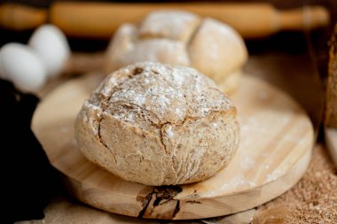 closeup of two round white breads, very crispy and rich, on a wooden board