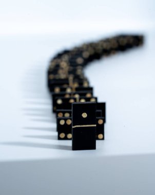 several black domino game tiles, forming a row. the first card is the one that corresponds to number one.