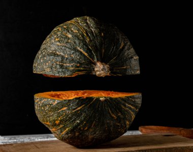 Bir balkabağı ikiye bölünmüş, üst kısmı havada, sanki uçuyormuş gibi..