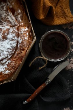 Ensaimada 'nın dikey görüntüsü, Mallorca, İspanya' nın tipik pastası, koyu bir arka planda.