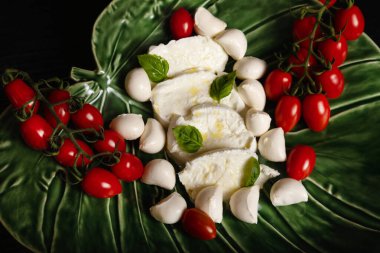 Yeşil tabakta kiraz domatesli Mozzarella.
