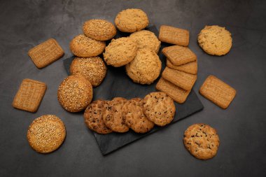 Siyah arkaplanda fırınlanmış kremalı kurabiye.