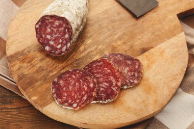 Ahşap arka planda dilimlenmiş İber kurutulmuş domuz sosisi.