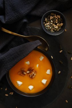 Koyu arkaplanda balkabağı kreması ve malzemeler. En üst görüntü