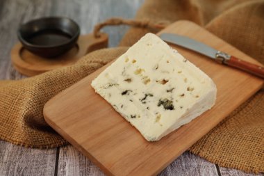 Ahşap arka planda lezzetli rokfor peyniri porsiyonu.