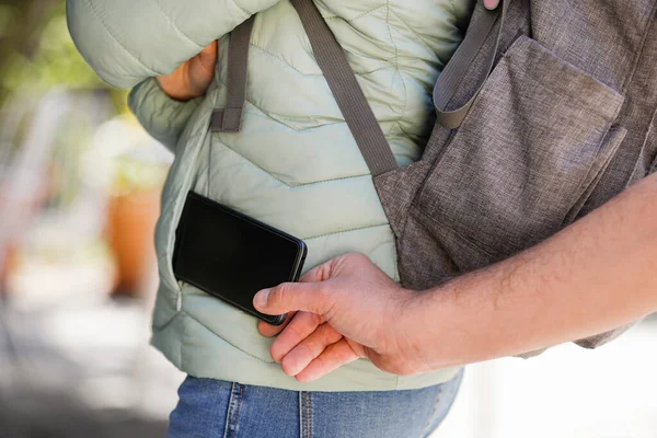 女の子のポケットから携帯電話を盗んだ男の手の詳細 — ストック写真