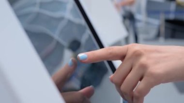 Modern müzede ya da sergide etkileşimli dokunmatik ekran kullanan kadın