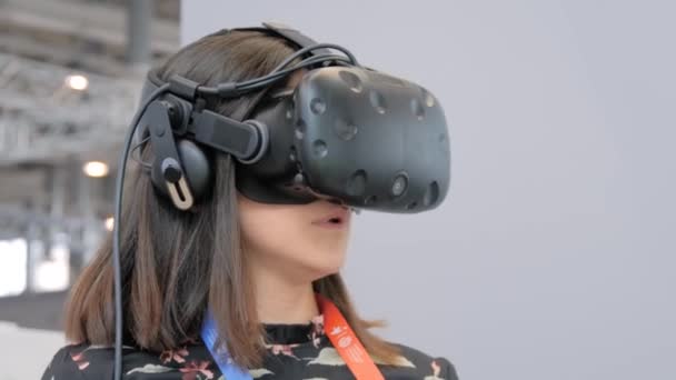 Mujer joven usando auriculares de realidad virtual en la exposición de tecnología VR: de cerca — Vídeo de stock