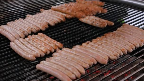 Chef asar embutidos de carne fresca en la gran parrilla redonda colgante - comida callejera — Vídeo de stock