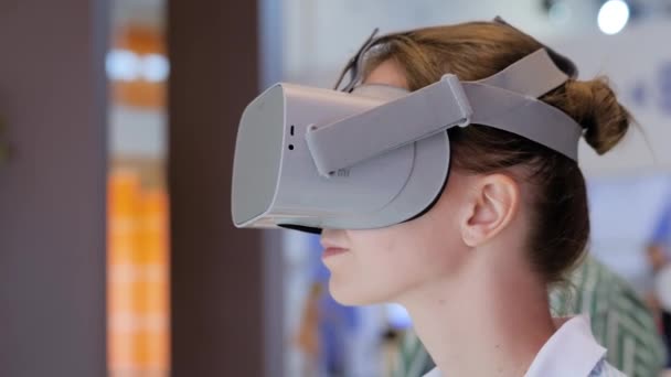Mujer joven usando auriculares de realidad virtual en la exposición de tecnología VR — Vídeos de Stock