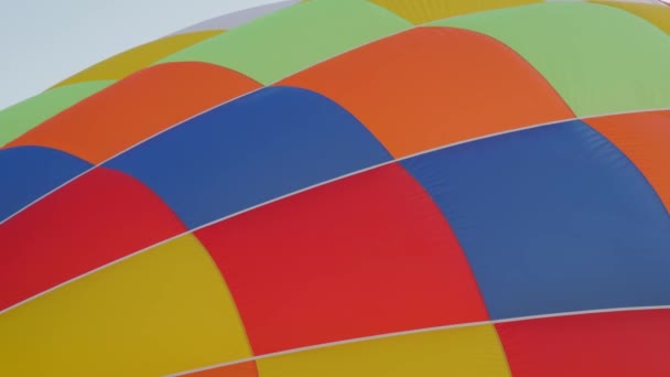 インフレーションの段階で熱気球のカラフルな封筒 屋外のエアロスタットフェスティバルでの打ち上げの準備 を閉じます スポーツの概念 — ストック動画