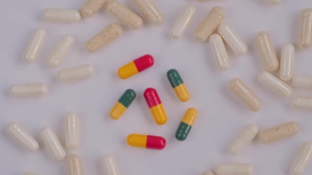 Prášky, tablety, léky, léky, léky rotující na bílém povrchu - zblízka — Stock video