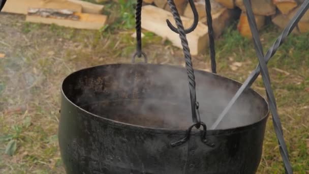 Медленное движение: приготовление пищи в подвешенном котле над открытым огнем - крупным планом — стоковое видео