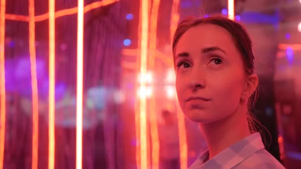 Retrato de mujer mirando a su alrededor en la exposición o museo con luz de colores — Vídeos de Stock