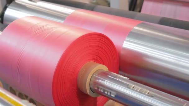 Close up: automatic plastic bag making machine - moving roller with pink film — Stock Video