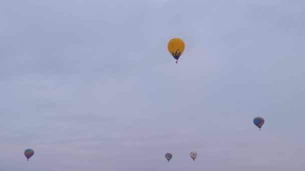 Bunte Heißluftballons fliegen beim Flugplatzfest gegen grauen Winterhimmel — Stockvideo