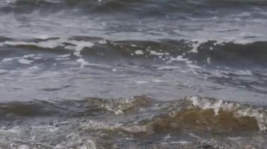 Yavaş çekim - deniz ya da nehir dalgaları sahile çarpıyor - yakın çekim