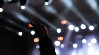 Yakın çekim: Sahnenin önündeki rock konserinde şeytan boynuzları gösteren adam