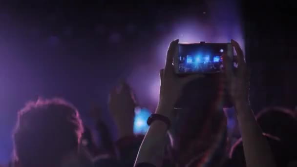 Жінка своїми руками записує відео концерт живої музики зі смартфоном — стокове відео