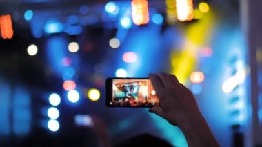 Yakın çekim: Adam akıllı telefonlu canlı müzik konseri videosu kaydediyor