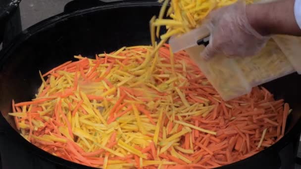 Chef cozinhar batata e cenouras fatias para pilaf, pilau em caldeirão enorme — Vídeo de Stock