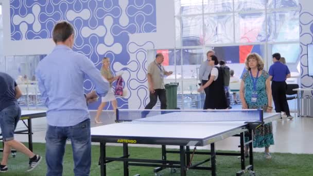 Mladý muž a starší žena hraje ping pong stolní tenis na sportovní výstavě — Stock video