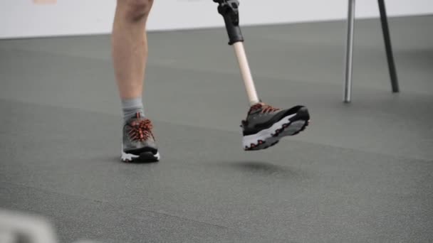 의족을 하고 적응력이 있는 스포츠 경기를 걷고 있는 장애인 남자: 가까이 다가가서 — 비디오