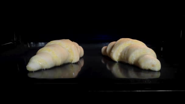 Timelapse - två hemmagjorda croissanter bakning och stiger i elektrisk ugn hemma — Stockvideo