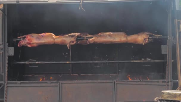 Cozinhar duas carcaças de carneiro no cuspo no mercado de comida de rua de verão: vista frontal — Vídeo de Stock