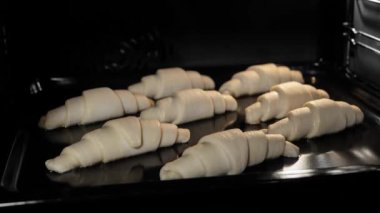 Zaman ayarlı - sekiz ev yapımı kruvasan evde elektrikli fırında pişiyor ve yükseliyor